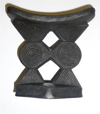 Lot 313 - A Mashona, Zimbabwe Ebonised Wood Neck Rest, with curved pillow on a pierced geometrically...