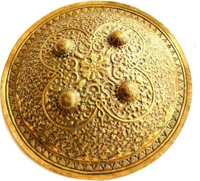 Lot 317 - An 18th Century Indo-Persian Brass Dhal, of convex form, richly embossed with scrolling leaves...