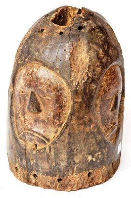 Lot 385 - A Mende Wood Helmet Mask, Sierra Leone, of arched form, carved with four solemn faces, 40cm (af)