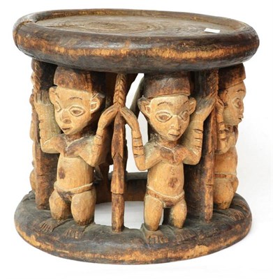 Lot 395 - A Yoruba Wood Stool, Nigeria, the circular seat with rounded edge, supported on the heads of...