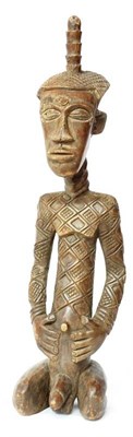 Lot 396 - An Ndengese Large Carved Wood Figure of a Chief, DCR,  kneeling, with diapered coiffure...