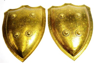 Lot 411 - A Pair of Benares Brass Shields, each of formal domed shield shape with folded edge,...