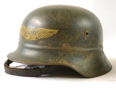 Lot 176 - A German Third Reich Luftschutz M40 Helmet, with green painted finish and gilt decal, the back...