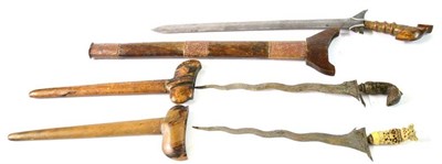 Lot 266 - A 19th Century Moro Kris, with 55cm double edge steel blade, the hardwood hilt with brass...