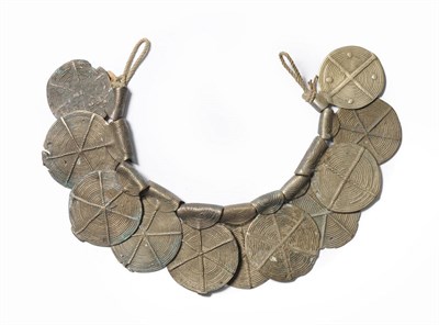 Lot 367 - An Abor, Assam Byop, made up of eleven brass discs, each of 8.5cm diameter, decorated with...