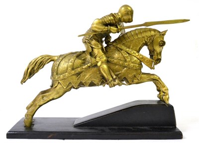 Lot 56 - A German Brass Model of a Medieval Jousting Knight, in full body armour, seated astride a...