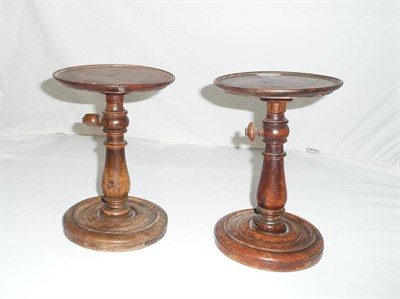 Lot 462 - A Pair of Turned Walnut Adjustable Candlestands, 19th century, the circular tops on turned and...