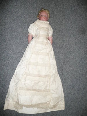 Lot 465 - A 19th Century Poured Wax Shoulder Head Doll with blue intaglio eyes, blond wig, on a padded...