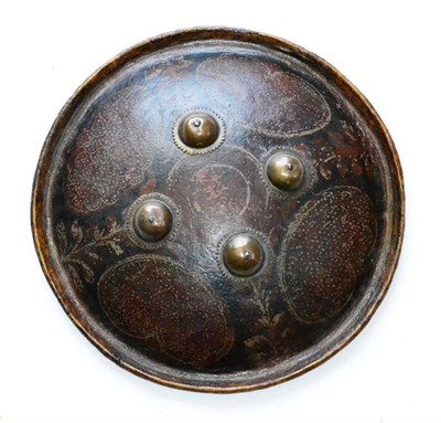 Lot 291 - An Indian Leather Dhal Shield, mounted with four brass bosses and polychrome painted with...