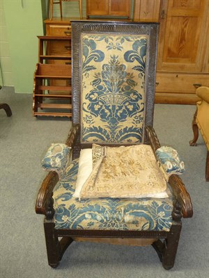 Lot 492 - A Carved Oak Armchair, with padded seat, back and arms, upholstered in blue floral printed...