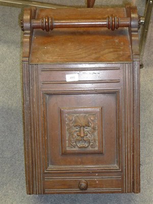 Lot 495 - A Late Victorian Carved Oak Coal Perdonium, the rosewood turned handle above a hinged lid with...