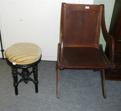 Lot 496 - A Late Victorian Oak Cross-Frame Armchair, with panel back and seat, the underside stamped IHH; and