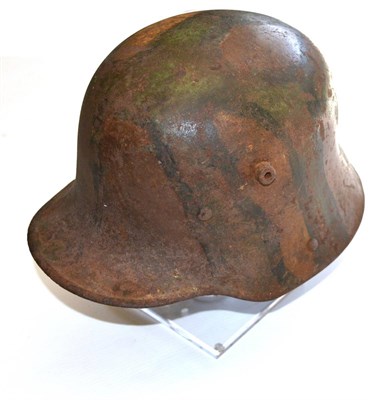 Lot 156 - A First World War German M1916 Helmet, with camouflage paint, bearing parts of the original...