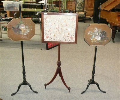 Lot 525 - A Pair of 19th Century Ebonised Pole Screens, the octagonal shaped boards painted with still...