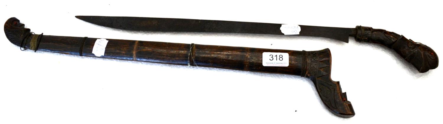 Lot 318 - A Javanese Klewang, with 44cm single curved edge steel blade, the totemic wood hilt carved as a...