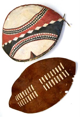 Lot 346 - A Zulu Dance Shield, of brown and white cow hide, with laced centreband, lacking its wood pole...