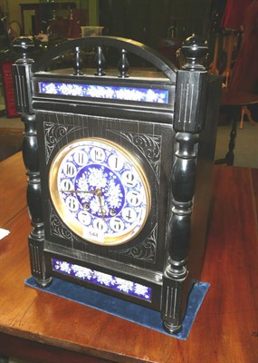 Lot 544 - An Arts and Crafts Mantel Clock, black ebonised case with applied blue and white floral ceramic...