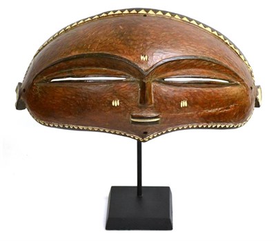 Lot 399 - An Eastern Pende (Congo) Carved and Painted Wood Mask, of curved, elongated oval form with dog...