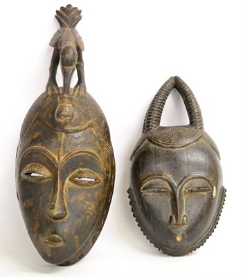 Lot 400 - A Baule (Ivory Coast) Carved Wood Mask, the elongated ovoid head with stylised coiffure,...