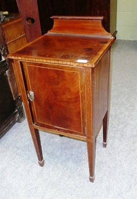 Lot 588 - An Edwardian Mahogany and Boxwood Strung Bedside Cupboard, the shaped pediment above a cupboard...