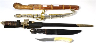 Lot 357 - A Moroccan Jambiya, with single edge curved steel blade, the silver and brass hilt and scabbard...