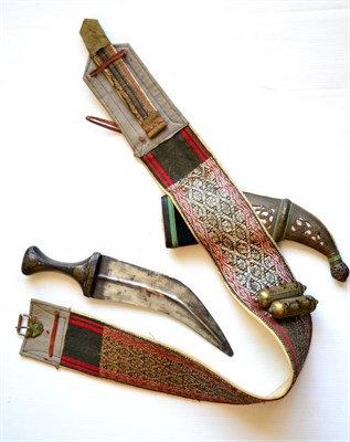 Lot 382 - An Omani Jambiya, the curved steel blade with raised medial ridge to each side, the horn hilt...