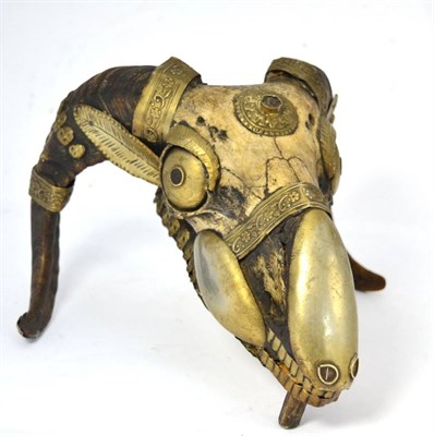 Lot 388 - A Nepalese/Tibetan Shaman Ram's Skull, with applied brass decoration to the horns, eyes, muzzle and