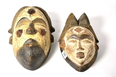 Lot 392 - A Punu Wood Mask, with double comb coiffure, oval face with white pigmentation, diamond...