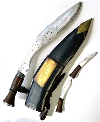 Lot 355 - A 1955 Gurkha Kukri, with chromed steel blade, wood grip with chromed pommel, in leather...