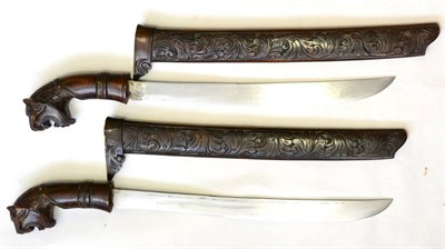 Lot 400 - Two Malayan Parangs, each with 38cm single edge steel blade, the wood hilt with tiger's head carved