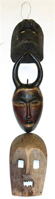 Lot 404 - A Baule Wood Mask, with horned headdress, the oval face with pierced slit eyes, aquiline nose,...