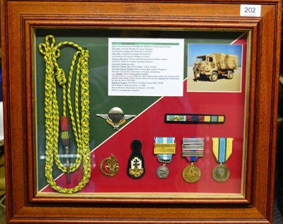 Lot 202 - French Foreign Legion, a framed display comprising fourragere, medals, badges, medal bar and...