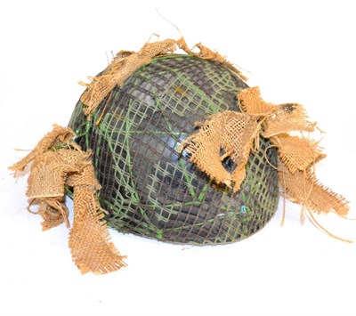 Lot 241 - A British Post Second World War Paratrooper's Helmet, with camouflage paint and netting, foam...