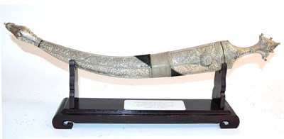 Lot 450 - An Early 20th Century Arab Jambiya, with 43cm curved double edge steel blade, the hilt and scabbard