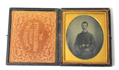 Lot 138 - A US Civil War Period Tintype, depicting a Union soldier seated half length, in a leather cloth...