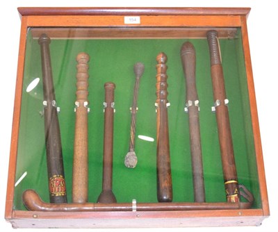 Lot 154 - A Mahogany Glazed Display of Truncheons, comprising a William IV ebonised example, painted in...