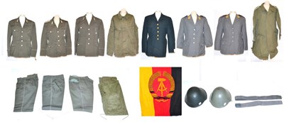 Lot 189 - A Quantity of East German Uniforms, including tunics, trousers, two belts and two helmets, together