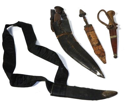 Lot 428 - A Nepalese Kukri, with wood grip and leather scabbard; a Sudanese Arm Dagger, with wood grip...