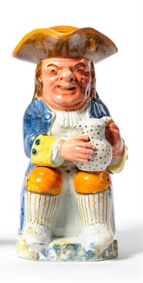 Lot 115 - A Pratt Type Pottery Toby Jug, circa 1790, of traditional form, holding a jug of ale, wearing ochre