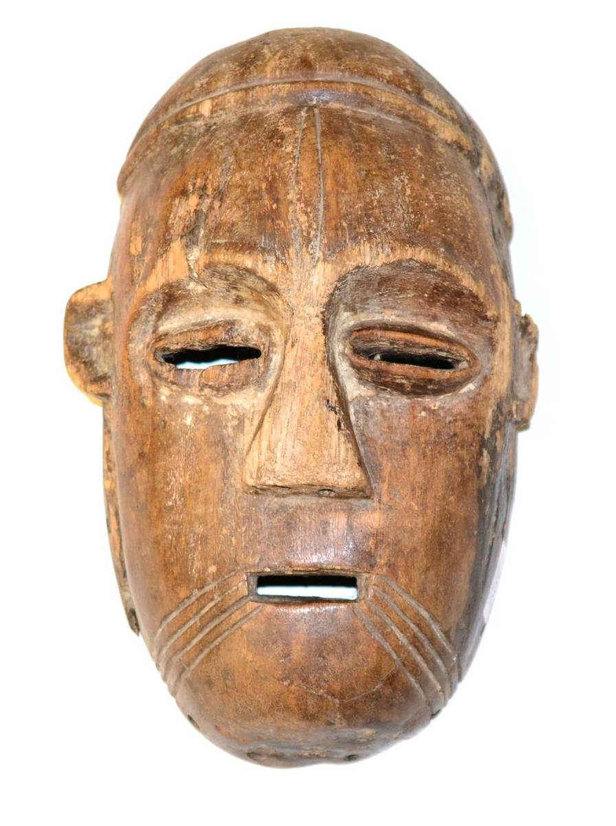 Lot 300 - A 20th Century Makonde Wood Face Mask, Mozambique, with rounded oval face, pierced eyes with...