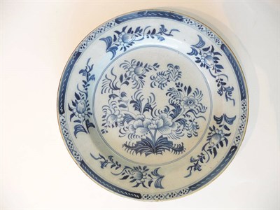 Lot 150 - An English Delft Charger, circa 1760, painted in blue with a flower spray within a border of...