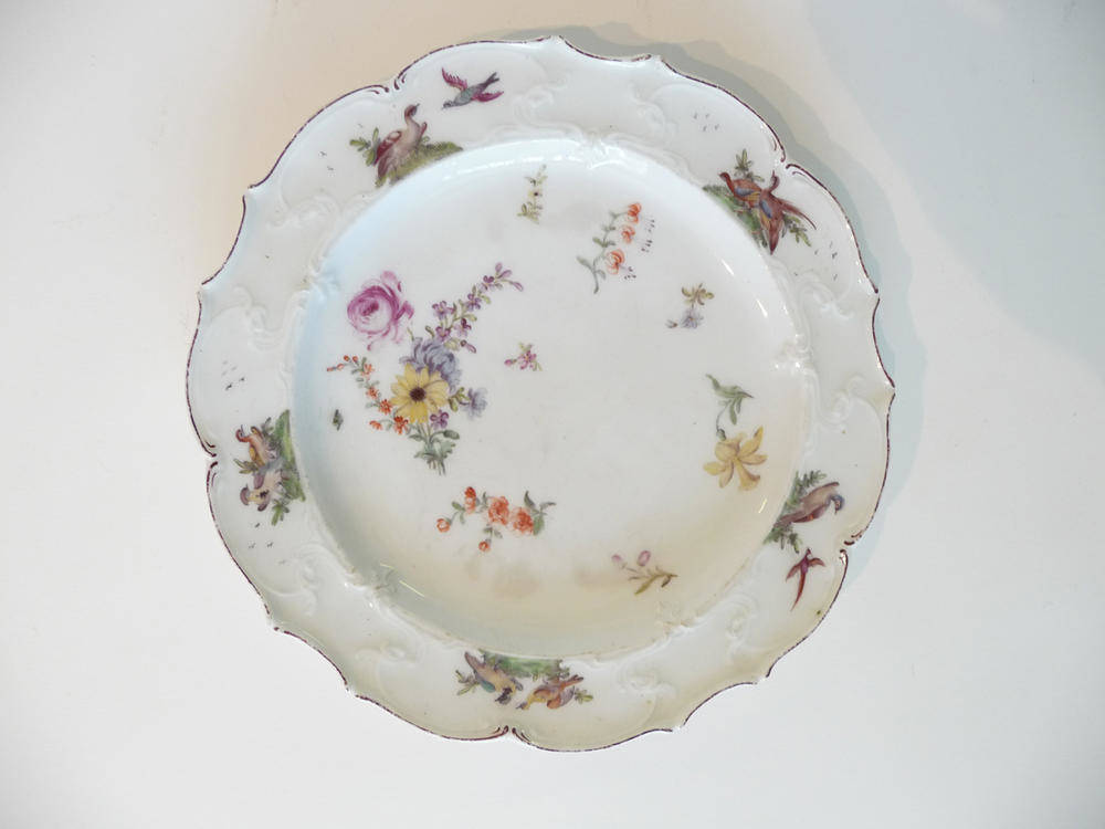 Lot 151 - A Chelsea Porcelain Plate, circa 1755, painted with a flowerspray and scattered sprigs within a...