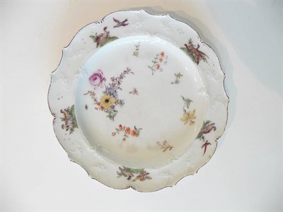 Lot 151 - A Chelsea Porcelain Plate, circa 1755, painted with a flowerspray and scattered sprigs within a...