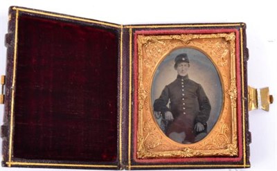 Lot 180 - An American Civil War Ambrotype Portrait of a Soldier, seated, half length, wearing a kepi and...