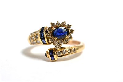 Lot 20 - A sapphire and diamond crossover ring, total estimated diamond weight 0.65 carat approximately,...