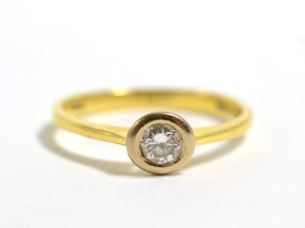 Lot 23 - An 18 carat gold solitaire diamond ring, a round brilliant cut diamond in a white gold rubbed...