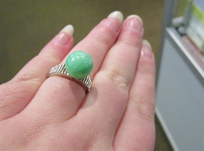Lot 46 - A jade ring, with tapering pierced shoulders, finger size N, stamped '18K' and with Chinese...