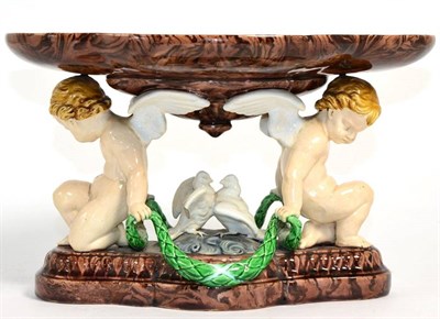 Lot 98 - A Minton Majolica centrepiece, 1870, the lobed oval bowl supported by two putti flanking a pair...