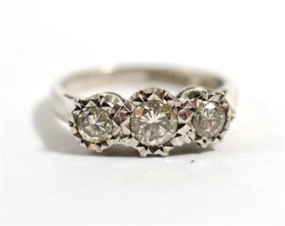 Lot 147 - An 18 carat white gold diamond three stone ring, graduated round brilliant cut diamonds in illusion
