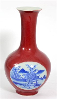 Lot 262 - A Chinese porcelain bottle vase, painted in underglaze blue with river landscapes on a coral...